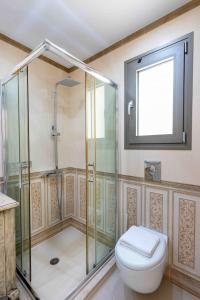 a bathroom with a glass shower and a toilet at House 55 in Arta