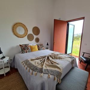 a bedroom with a bed and a large window at Monte das Açoteias - Agroturismo in Tavira