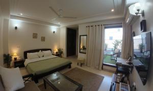 1 dormitorio con 1 cama y sala de estar en Niro GK2, en Nueva Delhi
