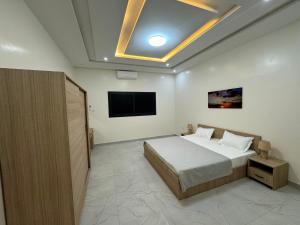 a bedroom with a bed and a flat screen tv at Complexe La Perfection in Nouakchott