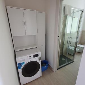a washing machine in a bathroom with a shower at ILLY HOUSE in Alghero
