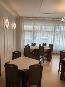 a dining room with tables and chairs and a window at Hotel Ana in Constanţa