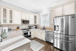 eine Küche mit weißen Schränken und einem Kühlschrank aus Edelstahl in der Unterkunft Quick Access Bus/Metro Gorgeous/Elegant Home in Arlington