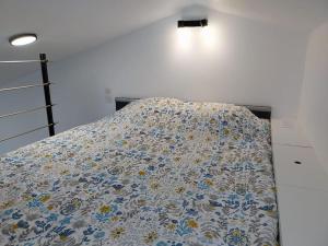 ein Bett mit einer Decke auf dem Zimmer in der Unterkunft studio Indépendant et climatisé. arrivée autonome in Bègles