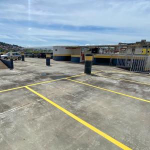 a parking lot with yellow lines in a parking lot at Elite Economy Hotel in Pará de Minas
