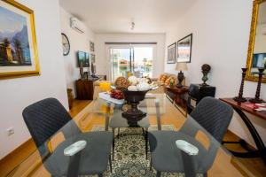 una sala de estar con una mesa y sillas en Santino Apartment, en Caniço