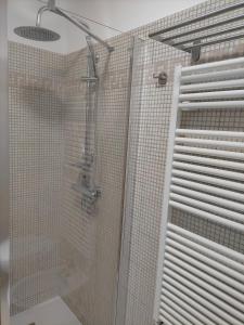 y baño con ducha y azulejos blancos. en appartamento incantevole a due passi dal mare a Viserbella vicino fiera Rimini en Rímini