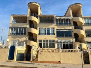 an apartment building with a fence in front of it at Lovely Apartament with a sunny terrace in Torrevieja