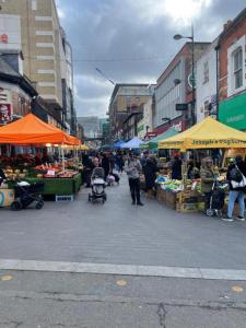 a market with fruits and vegetables on a city street at Inviting Studio Apartment - Central Croydon London in London