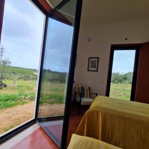 um quarto com uma cama e vista para um campo em Monte das Açoteias - Agroturismo em Tavira