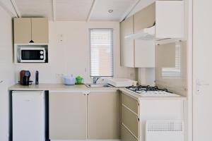 una cocina blanca con armarios blancos y fregadero en U Pezzo en Saint-Florent