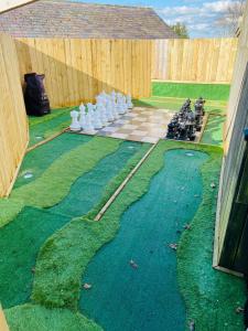 um campo de golfe com um jogo de xadrez na relva em Winnie Cottage - Hot Tub, Games Room, Sauna, Large Garden em Stocksfield