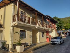 un coche blanco estacionado frente a un edificio en Apartamento Floripa 11, en Florianópolis