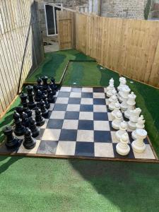 um tabuleiro de xadrez num relvado com um tabuleiro de xadrez em Winnie Cottage - Hot Tub, Games Room, Sauna, Large Garden em Stocksfield