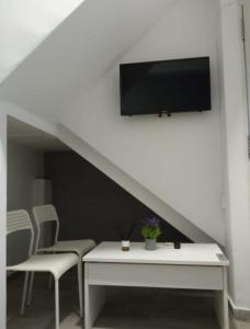 - un salon avec une télévision, une table et des chaises dans l'établissement Estudio en Jerez, à Jerez de la Frontera