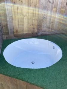 a white bath tub sitting on a green carpet at Winnie Cottage - Hot Tub, Games Room, Sauna, Large Garden in Stocksfield