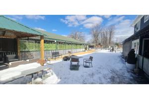 un patio con bancos y mesas en la nieve en Werry's Cottages Motel & Pub by OYO East Stroudsburg Poconos en East Stroudsburg