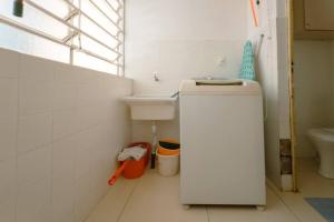 a white bathroom with a sink and a toilet at Espaçoso e Confortável Próximo da UEM - EL08 in Maringá