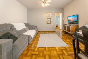 a living room with a couch and a flat screen tv at Espaçoso e Confortável Próximo da UEM - EL08 in Maringá