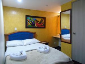 - une chambre avec 2 lits et des serviettes dans l'établissement Hotel Restaurante El Madroño Chia, à Chía