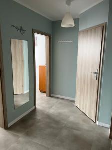 an empty room with a door and a mirror at eMKa Noclegi apartamenty in Augustów