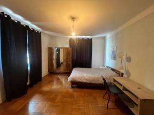um quarto com uma cama e piso em madeira em Welcome em Chambéry