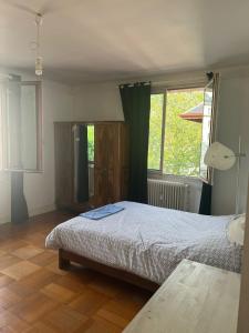 a bedroom with a bed and a large window at Welcome in Chambéry