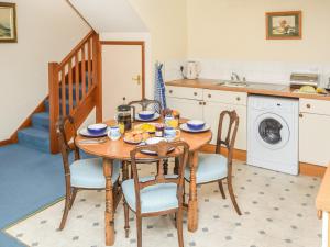 een keuken met een houten tafel met stoelen en een wastafel bij 2 Bed in Blackwater IC082 in Newport