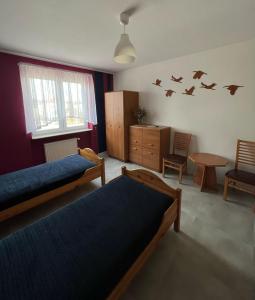 um quarto com duas camas e pássaros na parede em eMKa Noclegi apartamenty em Augustów