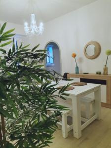 einen weißen Tisch und eine Pflanze in einem Raum in der Unterkunft L'Arco Verde in Trabia
