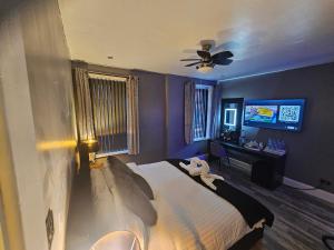 Tamarind Cove & Barrons Hotel في بلاكبول: غرفة نوم بسرير ومروحة سقف