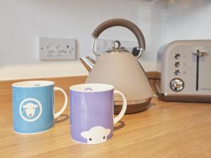 three coffee mugs sitting on a counter with a tea kettle at 4 Bed in Keswick SZ443 in Keswick