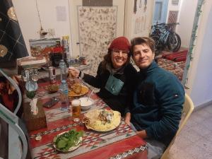 mężczyzna i kobieta siedzący przy stole z jedzeniem w obiekcie Beit alkaram w mieście Al-Karak
