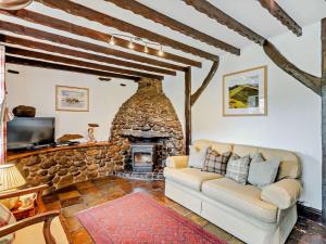 a living room with a couch and a stone fireplace at 3 Bed in Bampton 92037 in Bampton