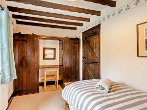 班普頓的住宿－3 Bed in Bampton 92037，一间卧室设有一张床和木墙