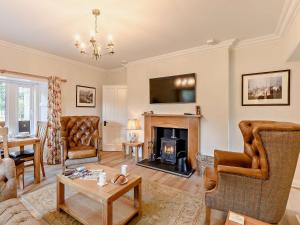 uma sala de estar com uma lareira e uma mesa em 2 Bed in Hawick 91905 em Roberton