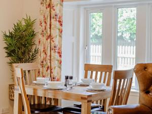 uma mesa de jantar com cadeiras e uma mesa de madeira com copos em 2 Bed in Hawick 91905 em Roberton