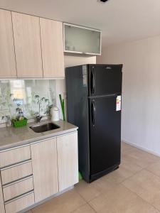 a kitchen with a black refrigerator and a sink at Río Grande Buena Vista in Río Grande