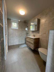 東卡佩勒的住宿－Luxe lodges met airco，带浴缸、盥洗盆和卫生间的浴室