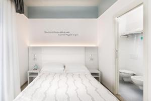 um quarto branco com uma cama e um lavatório em Hotel Eliseo em Bellaria-Igea Marina