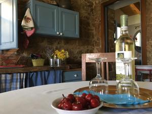 una botella de vino y un tazón de cerezas en una mesa en Agriturismo La Casa delle Fate, en Loiri