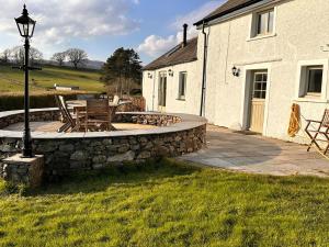 a patio with a stone wall next to a house at 5 Bed in Broughton-In-Furness 93178 in Broughton in Furness