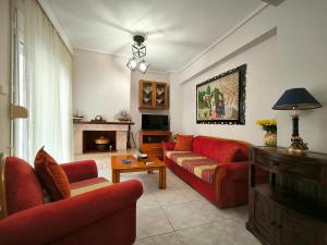 a living room with red furniture and a fireplace at Simos Summer House in Fanari in Fanárion