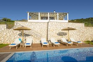 a group of chairs and umbrellas next to a pool at Villa Drimonas Artemis by Villa Plus in Drymon