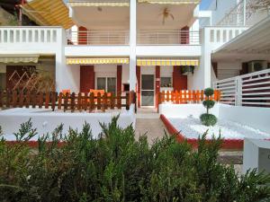 a large white building with a patio with orange chairs at Simos Summer House in Fanari in Fanárion