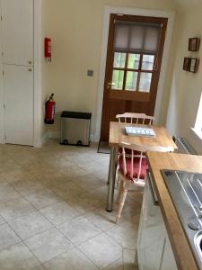 a kitchen with a wooden table and a counter top at Cottage in Ayr