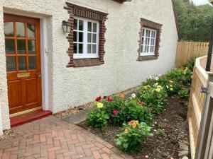 a house with a door and flowers in front of it at Cottage in Ayr