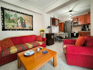 a living room with two red couches and a table at Simos Summer House in Fanari in Fanárion