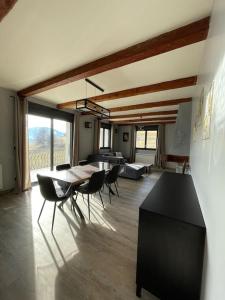 een eetkamer met een tafel en stoelen in een kamer bij Le Panoramique, Calme - Spacieux in Chateauroux-les-Alpes