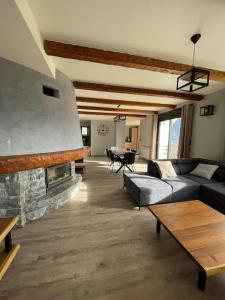 een woonkamer met een bank en een open haard bij Le Panoramique, Calme - Spacieux in Chateauroux-les-Alpes